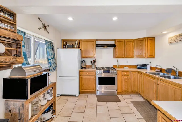 a kitchen with stainless steel appliances granite countertop a refrigerator and a stove top oven