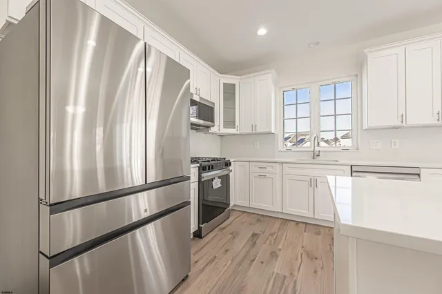 a kitchen with a refrigerator sink and cabinets