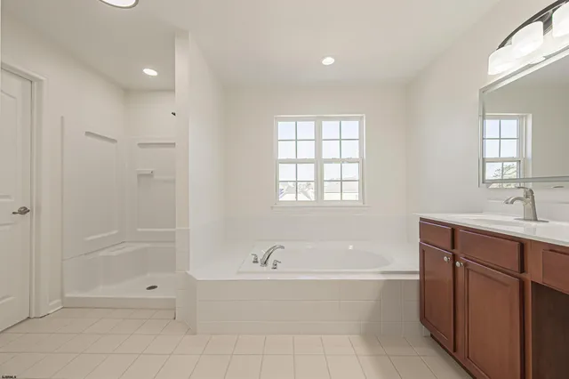a spacious bathroom with a tub shower sink and mirror