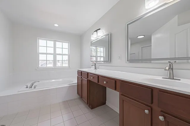 a bathroom with a tub sink and mirror