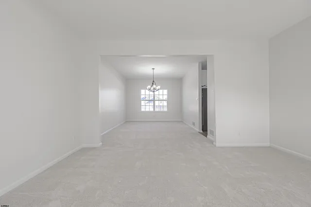 an empty room with windows and mirror