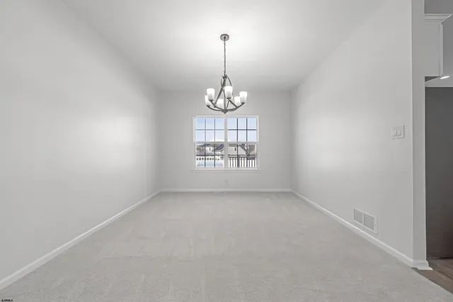 an empty room with windows and ceiling fan