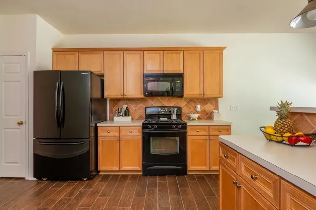 a kitchen with a refrigerator stove and wooden cabinets