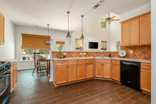 a kitchen with stainless steel appliances granite countertop a stove a sink and a wooden floors