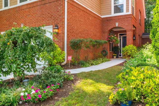 a front view of a house with a yard and fountain in middle
