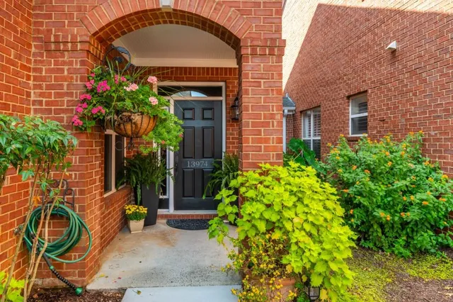a view of brick house with potted plants