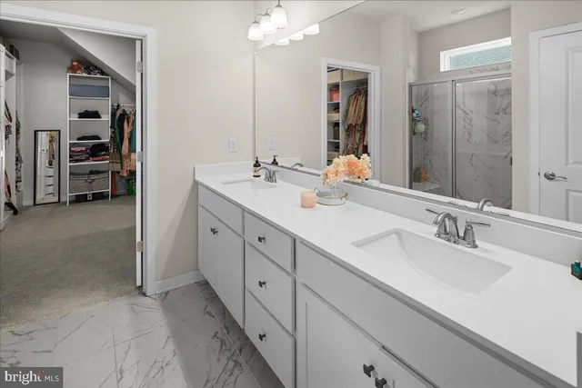 a bathroom with double vanity sinks and a mirror