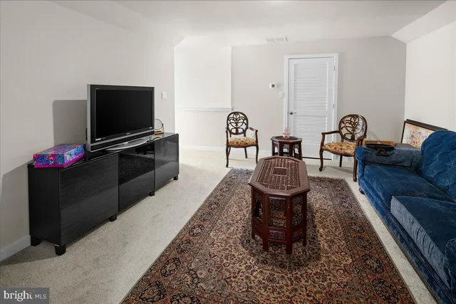 a living room with furniture a flat screen tv and kitchen view