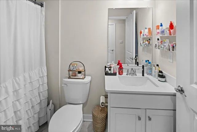 a bathroom with a sink a toilet and a shower curtain