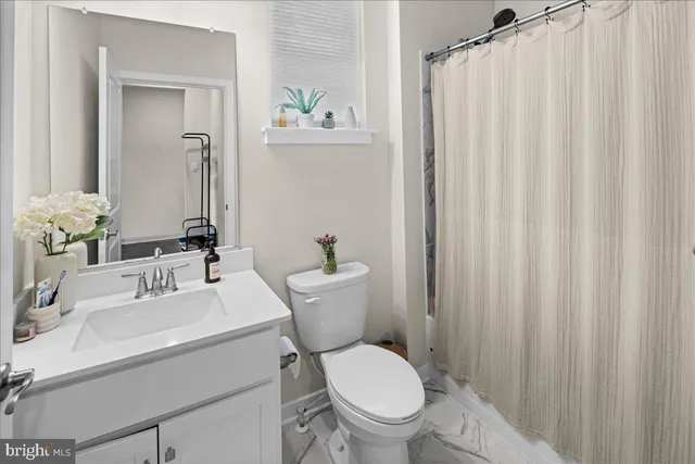 a bathroom with a sink a toilet and shower curtain