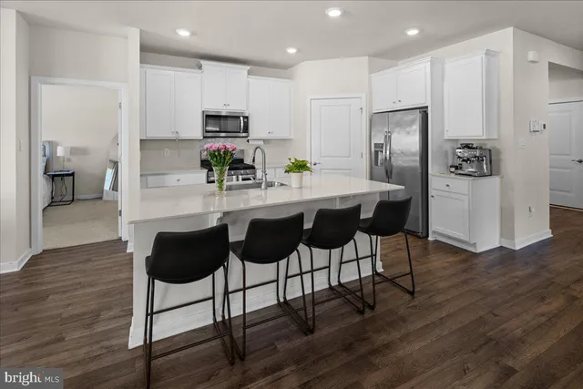 a kitchen with stainless steel appliances granite countertop a refrigerator and a stove top oven