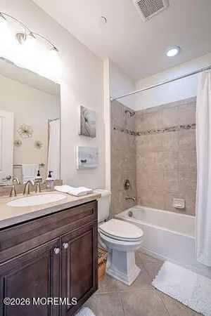 a spacious bathroom with a sink a toilet and a large mirror