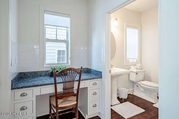 a bathroom with a granite countertop toilet sink and mirror