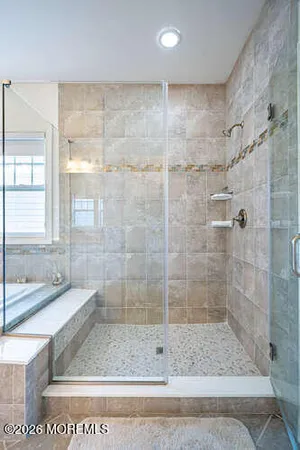 a kitchen with granite countertop a refrigerator a stove a sink and white cabinets with wooden floor