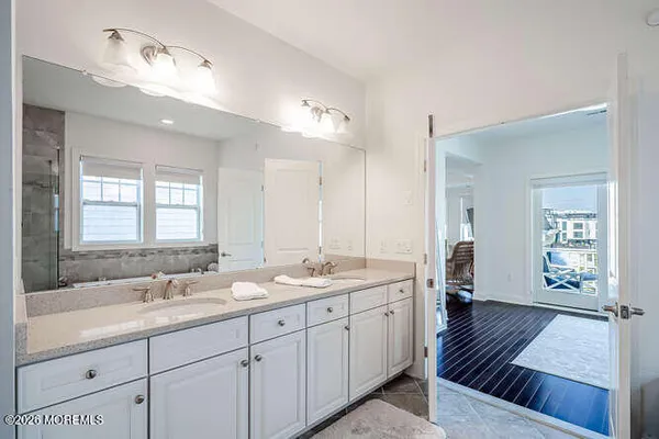 a spacious bathroom with a double vanity sink a mirror and a shower