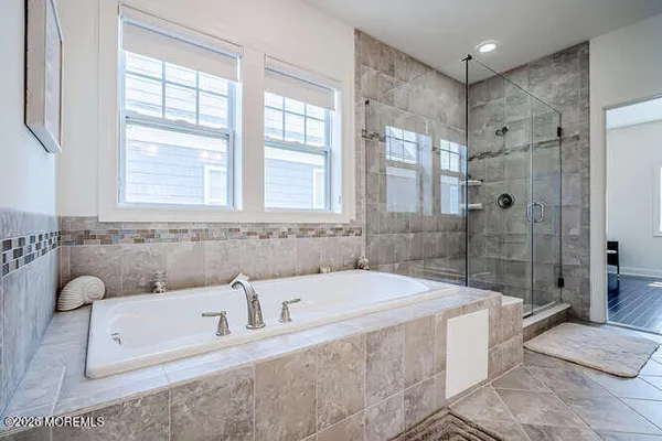 a bathroom with a tub shower and sink