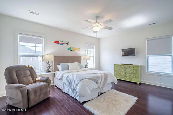 a bedroom with a bed couches chair and a window