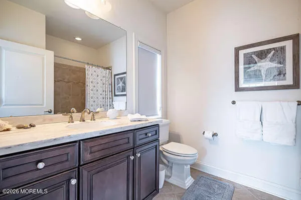a bathroom with a granite countertop toilet sink and mirror