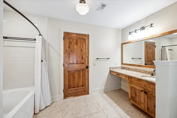 a bathroom with a tub sink and mirror