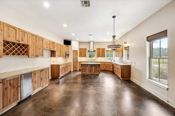 a large white kitchen with lots of counter space wooden floor and stainless steel appliances
