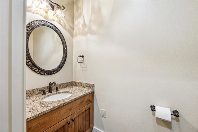 a bathroom with a granite countertop sink and a mirror