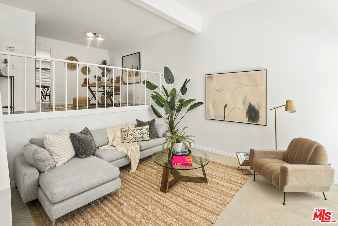 a living room with furniture flowerpot and wooden floor