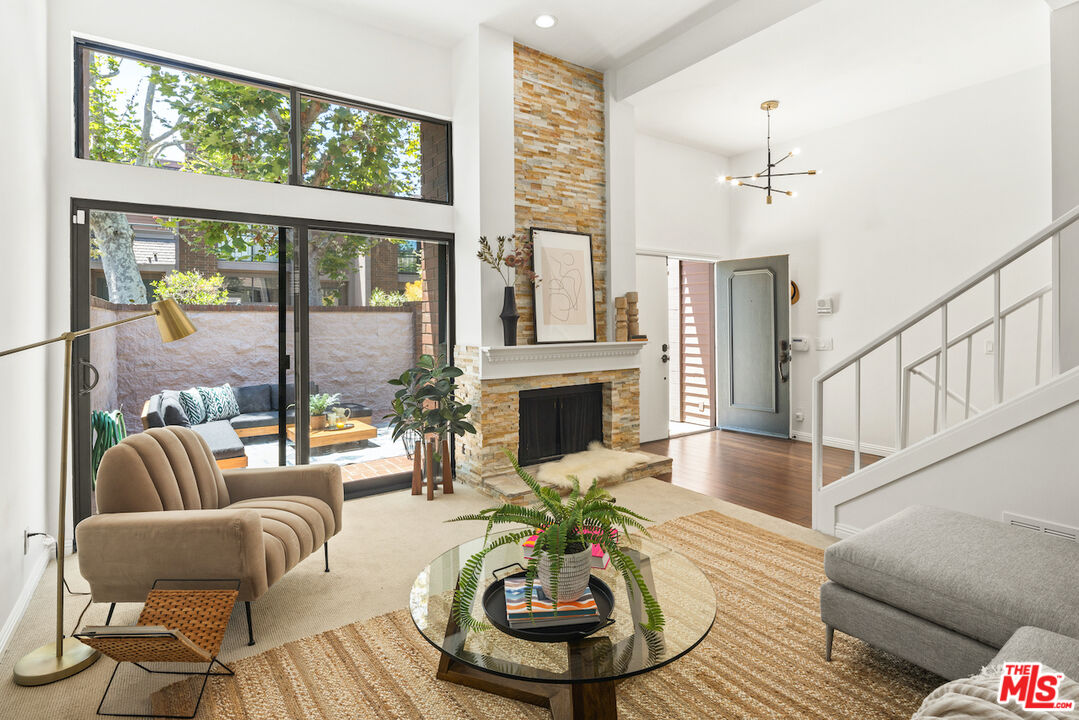 4549 Alla Road, Unit 5 Marina del Rey, CA 90292 - Photo 7 of 35 a living room with furniture a fireplace and a floor to ceiling windows