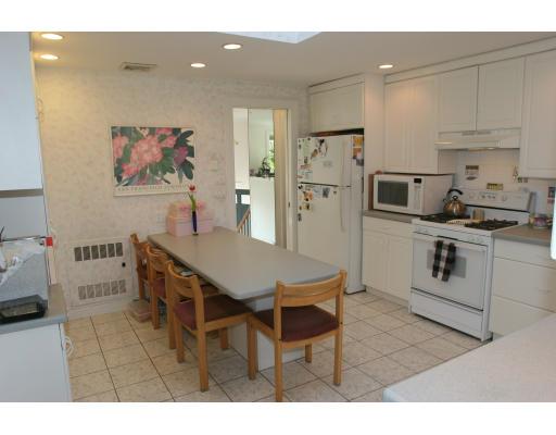 42 Hewitt Circle Needham, MA 02494 - Photo 4 of 10 a kitchen with stainless steel appliances kitchen island granite countertop a table chairs sink and cabinets