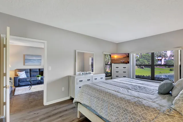 a view of a room with a large window and wooden floor