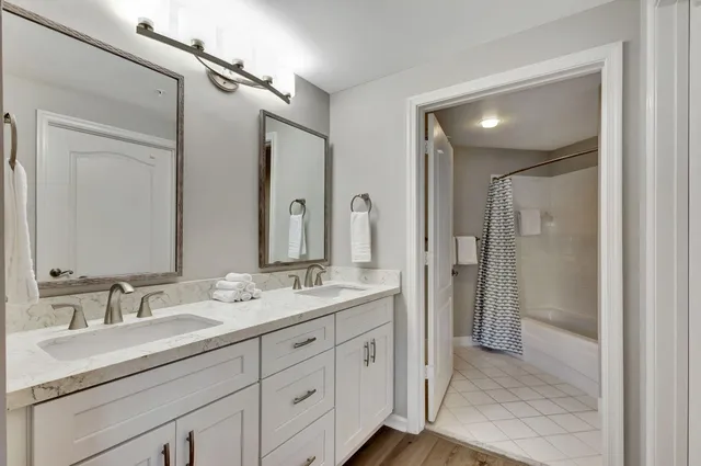 a bathroom with double vanity sinks and a mirror