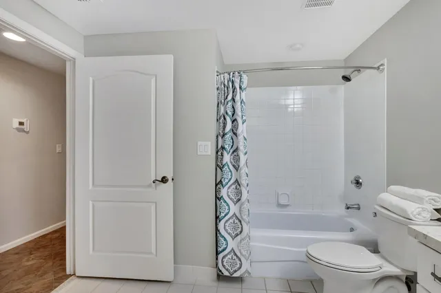 a bedroom with a bed and a lamp with the dresser