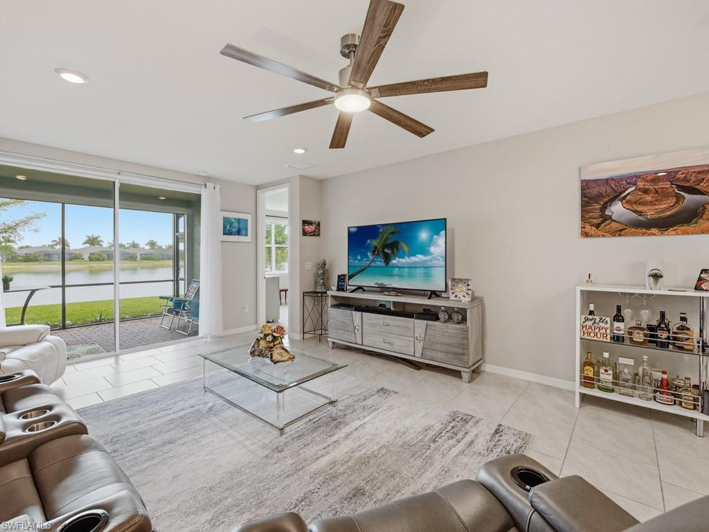 14591 Edgewater Circle Naples, FL 34114 - Photo 5 of 36 Living room featuring light tile patterned floors, a ceiling fan, tv stand and LG TV