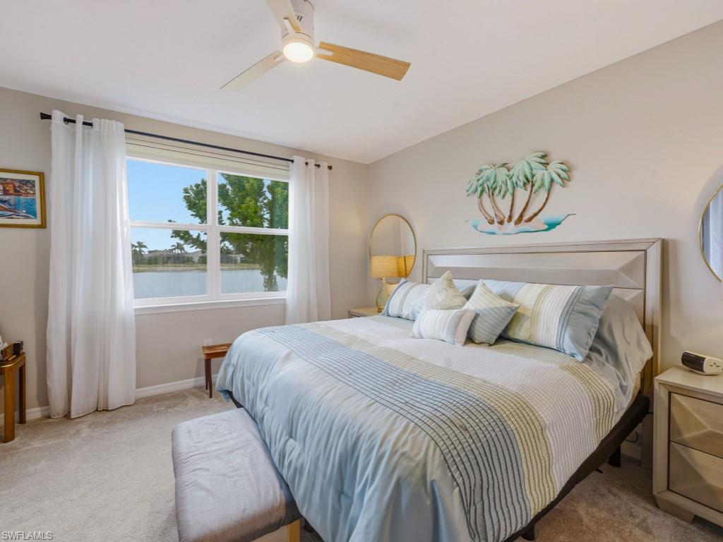 14591 Edgewater Circle Naples, FL 34114 - Photo 8 of 36 Carpeted bedroom with a water view, a ceiling fan, and vaulted ceiling