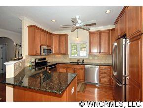52 Carriage Spring Way Hendersonville, NC 28791 - Photo 5 of 12 a kitchen with kitchen island granite countertop a sink appliances cabinets and a counter top space