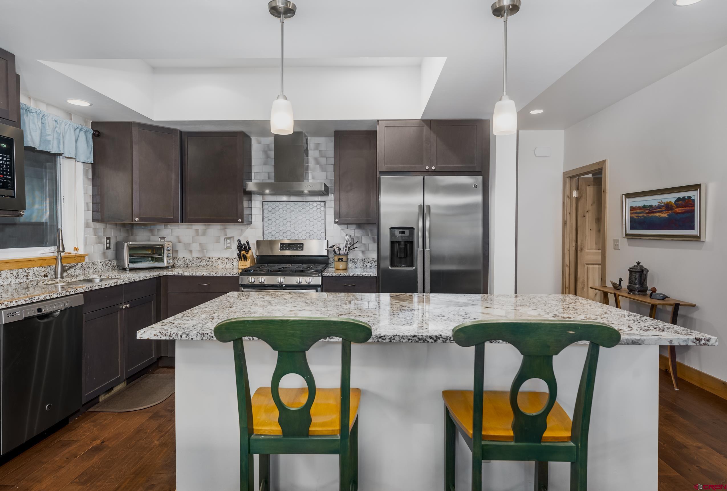 41 Mountain Stream Court Durango, CO 81301 - Photo 20 of 29 a kitchen with stainless steel appliances granite countertop a kitchen island a stove a sink a dining table and chairs