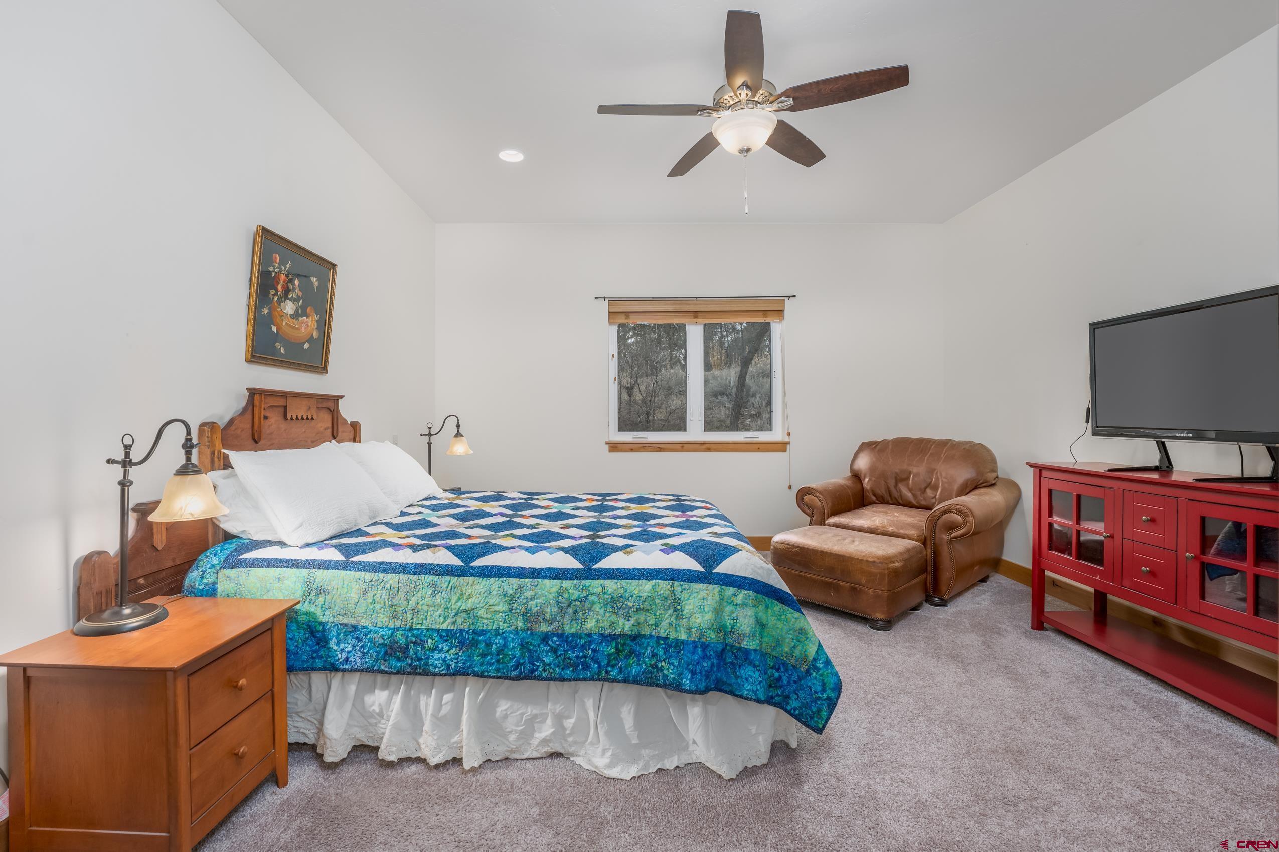 41 Mountain Stream Court Durango, CO 81301 - Photo 8 of 29 a bedroom with furniture and a flat screen tv