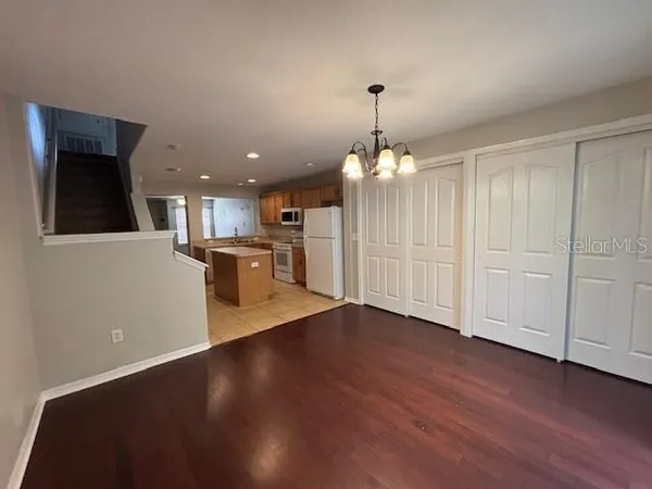 wooden floor in an empty room with a kitchen