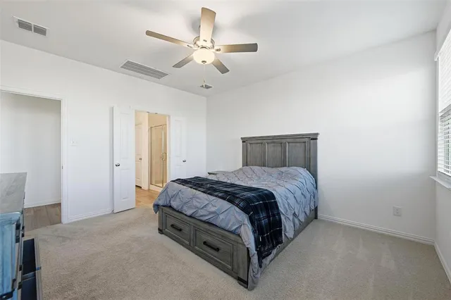 a spacious bedroom with a bed and a ceiling fan