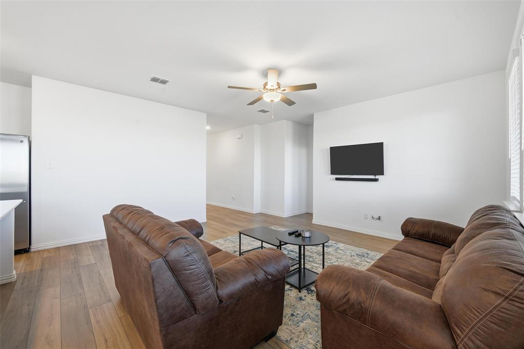 216 Post Oak Street Azle, TX 76020 - Photo 25 of 39 a living room with furniture and a flat screen tv
