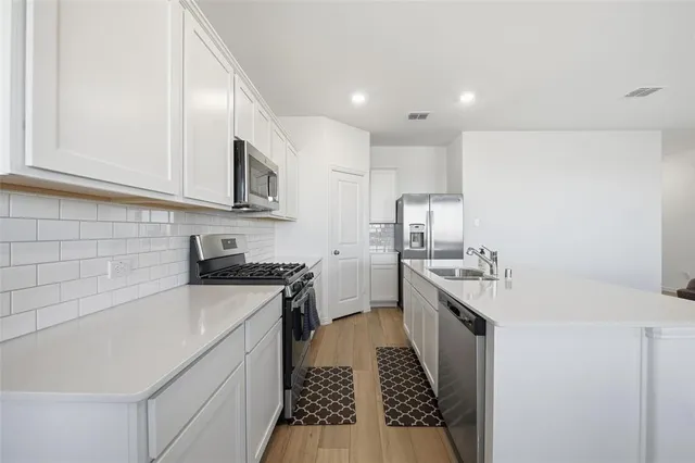 a kitchen with a sink stove and cabinets