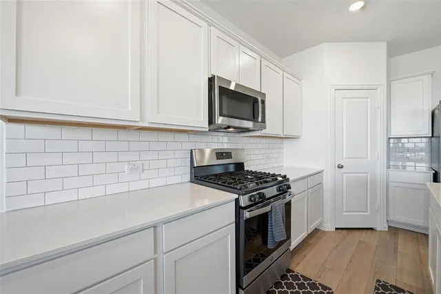 a kitchen with stainless steel appliances granite countertop a sink a stove and a microwave
