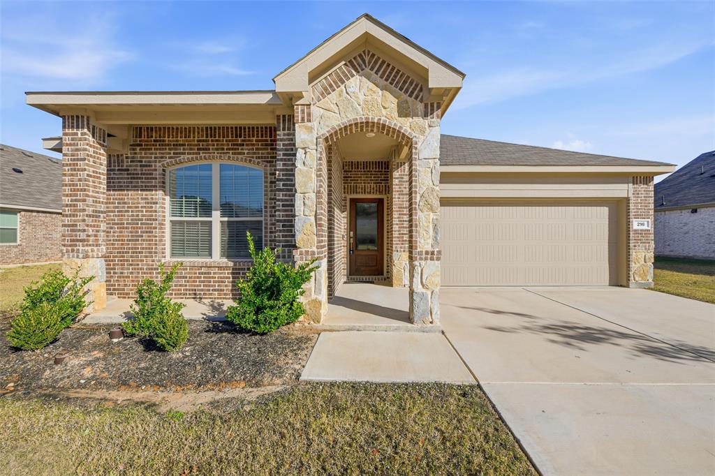 216 Post Oak Street Azle, TX 76020 - Photo 3 of 39 View of front of home featuring brick siding, stone siding, concrete driveway, and a garage