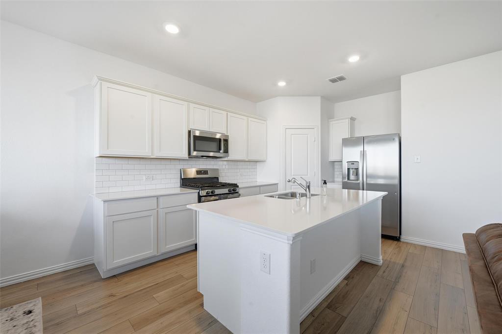 216 Post Oak Street Azle, TX 76020 - Photo 32 of 39 a kitchen with appliances a sink and cabinets