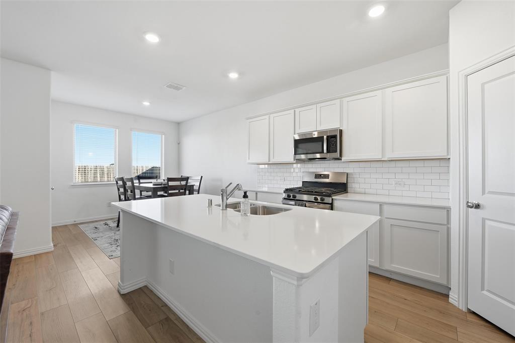 216 Post Oak Street Azle, TX 76020 - Photo 33 of 39 a kitchen with a sink a stove a microwave and cabinets
