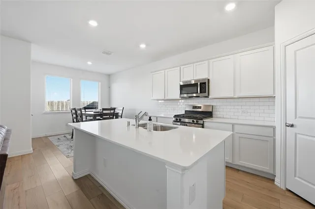 a kitchen with a sink a stove a microwave and cabinets