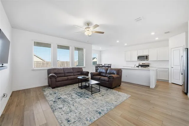 a living room with furniture and kitchen view