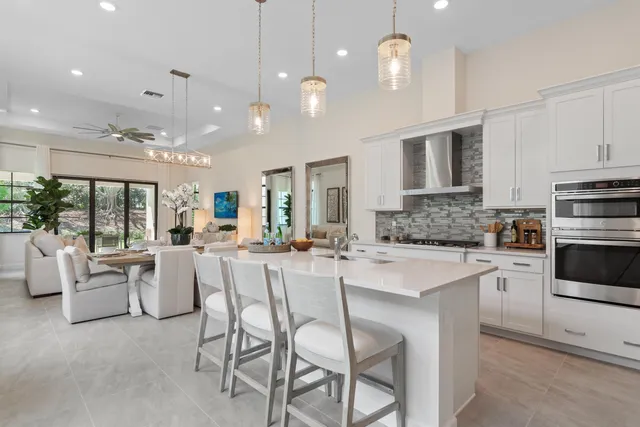 a large kitchen with kitchen island stainless steel appliances a stove a table and chairs