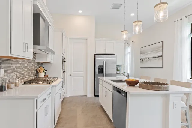 a kitchen with a stove a sink a dining table and chairs