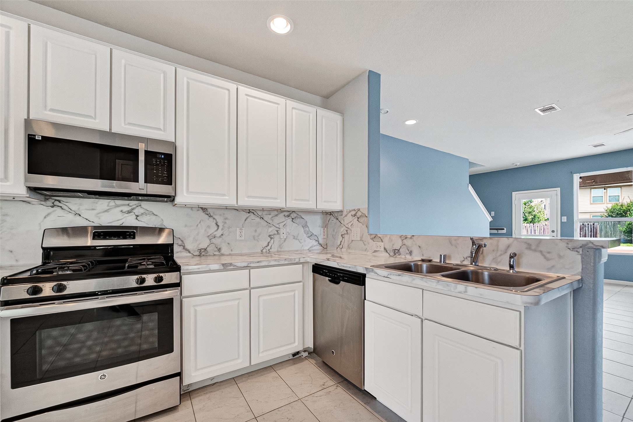 2702 Modano Court Fresno, TX 77545 - Photo 9 of 46 a kitchen with white cabinets and black appliances