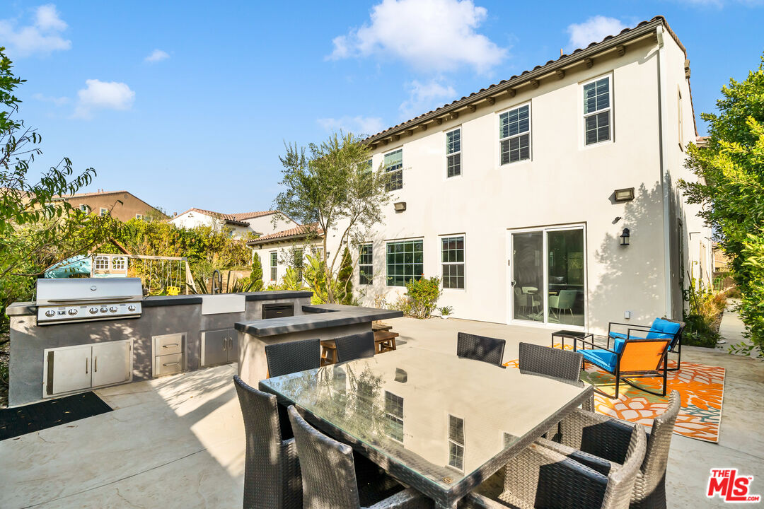 7313 Rocky Top Circle Moorpark, CA 93021 - Photo 26 of 33 a view of a patio with couches table and chairs under an umbrella with wooden floor